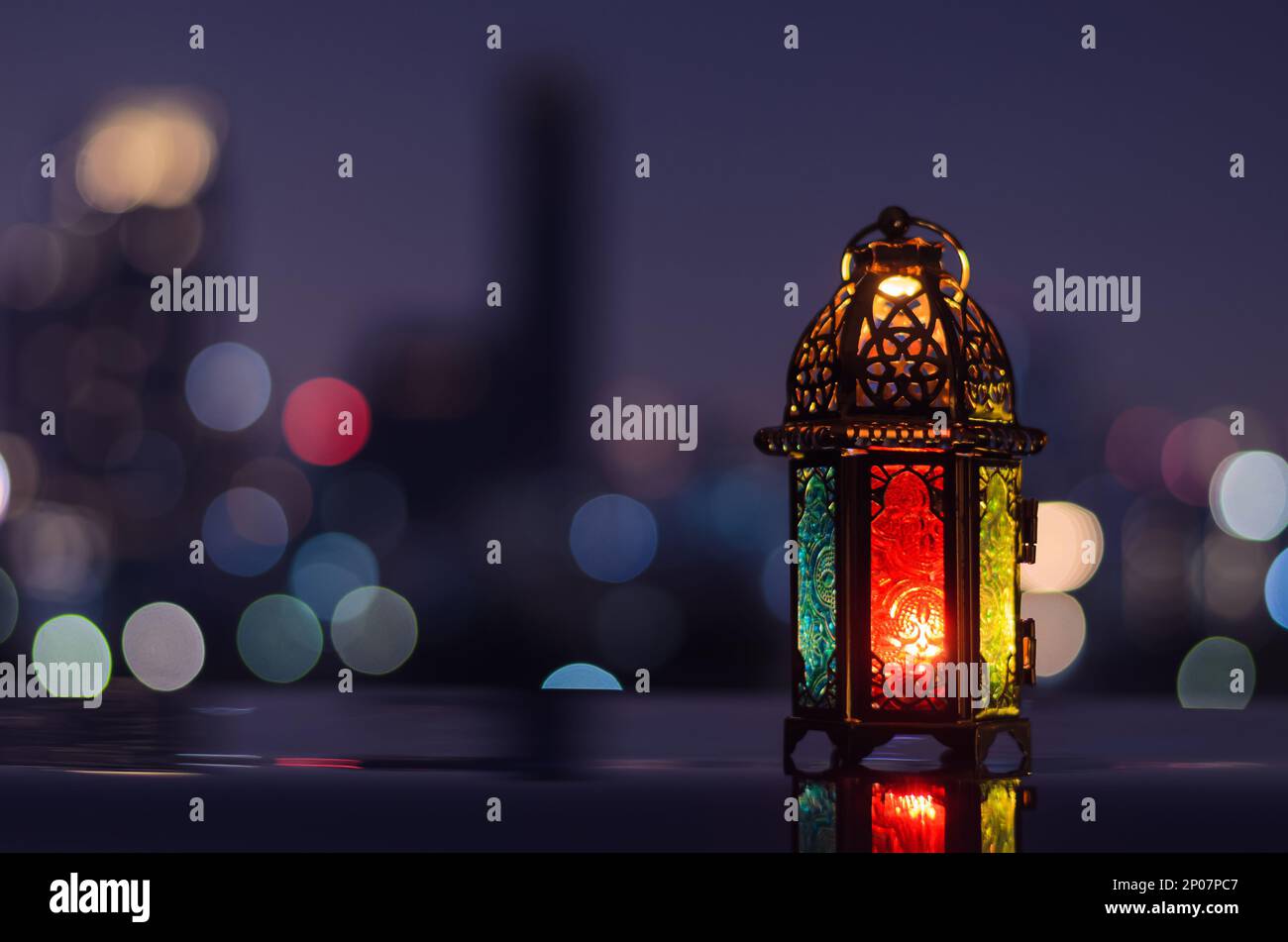 Lanterna con cielo notturno e città bokeh sfondo luminoso per la festa musulmana del mese santo di Ramadan Kareem. Foto Stock