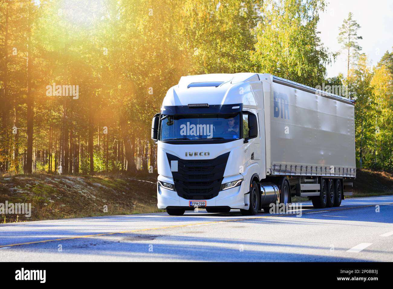 Nuovo veicolo Iveco S-Way bianco davanti al semirimorchio sull'autostrada 25 alla luce del sole del mattino. Raasepori, Finlandia. Settembre 23, 2022. Foto Stock