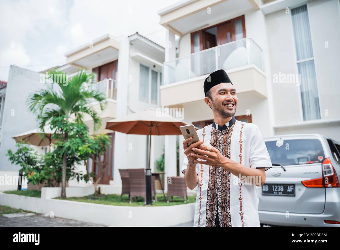 Uomo musulmano asiatico con songkok utilizzando smartphone Foto Stock