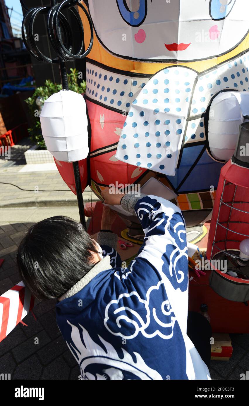 Un uomo giapponese che lavora su un galleggiante gigante in preparazione al festival del nebua ad Asakusa, Tokyo, Giappone. Foto Stock