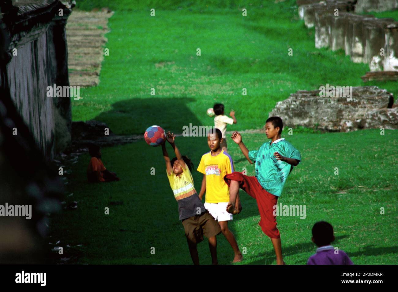 I bambini giocano a calcio su un campo d'erba tra le rovine del Kaibon Palace, un patrimonio culturale del periodo Sultanato di Banten situato in un'area chiamata Banten lama (Old Banten) a Serang, Banten, Indonesia, in questa foto scattata nel 2004. Una ricerca sul campo condotta recentemente da Nurikah e E. Rakhmat Jazuli (Facoltà di giurisprudenza, Sultan Ageng Tirtayasa University, Banten) ha rivelato che ci sono state molte violazioni contro il trattamento dei beni culturali nella zona. La gente sta "svolgendo attività sportive nell'ambiente di beni culturali, per esempio giocando a calcio su... Foto Stock