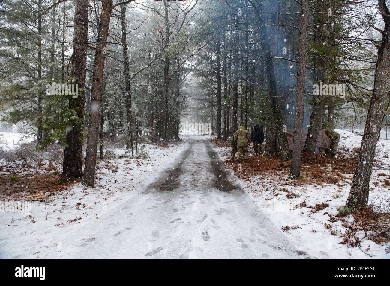 STATI UNITI Air Force Airmen del 290th Joint Communications Support Squadron assemblare rifugio 9 febbraio 2023, presso Alpena Combat Readiness Training Center, Michigan. Gli Airmen stanno frequentando una classe guidata da specialisti di Survival, Evasion, Resistance and Escape (SERE) per insegnare loro le tecniche di sopravvivenza di base in un ambiente freddo. Foto Stock