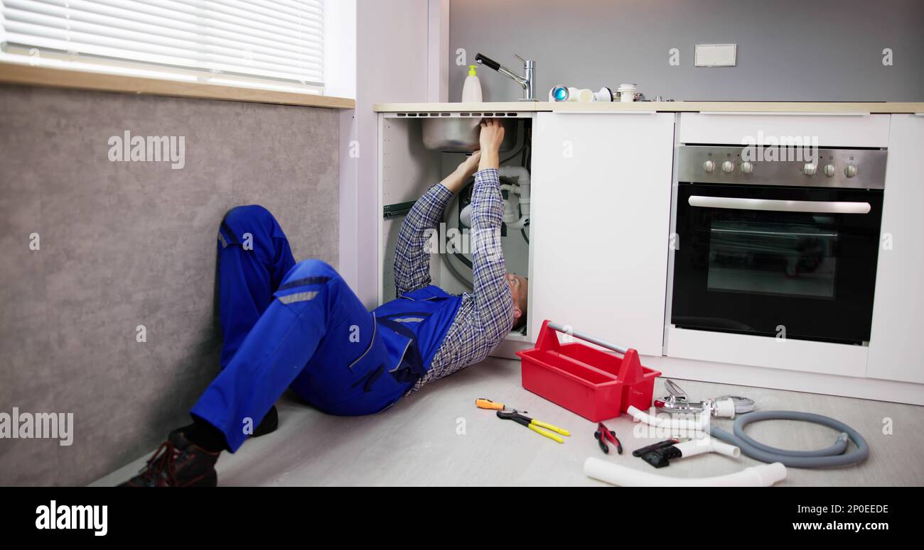 Pulizia dell'idraulico scarico cucina e tubo con attrezzi Foto Stock