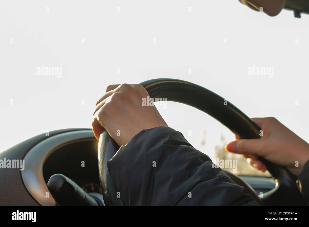 mani sul volante all'interno della vettura nel pomeriggio Foto Stock