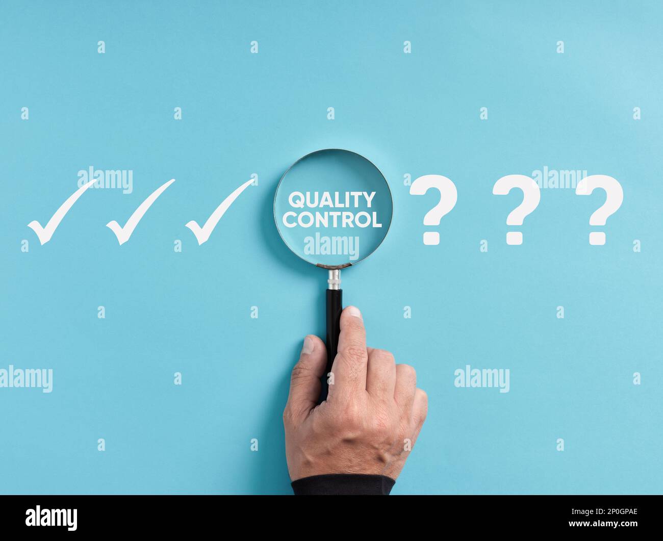 Tecnologia aziendale e controllo di qualità industriale nella produzione. La mano tiene la lente d'ingrandimento focalizzandosi sulla parola controllo qualità accanto al punto interrogativo e. Foto Stock