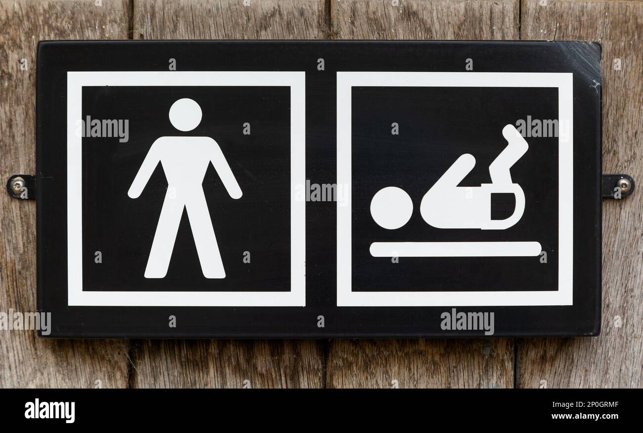 Segno di gabinetto maschio con bambino pannolino cambiante struttura, Regno Unito Foto Stock