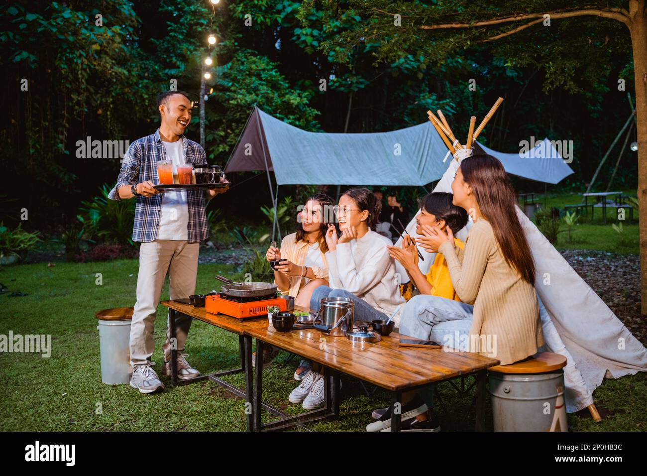 il ragazzo in camicia plaid in piedi e portare le bevande Foto Stock