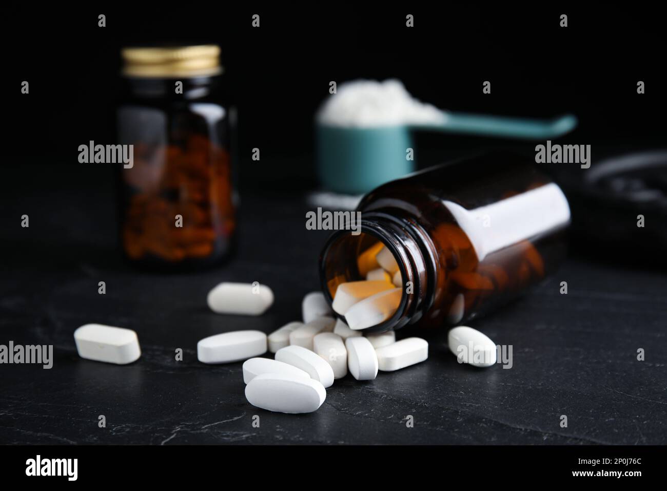 Flacone e pillole di aminoacidi su tavolo nero Foto Stock