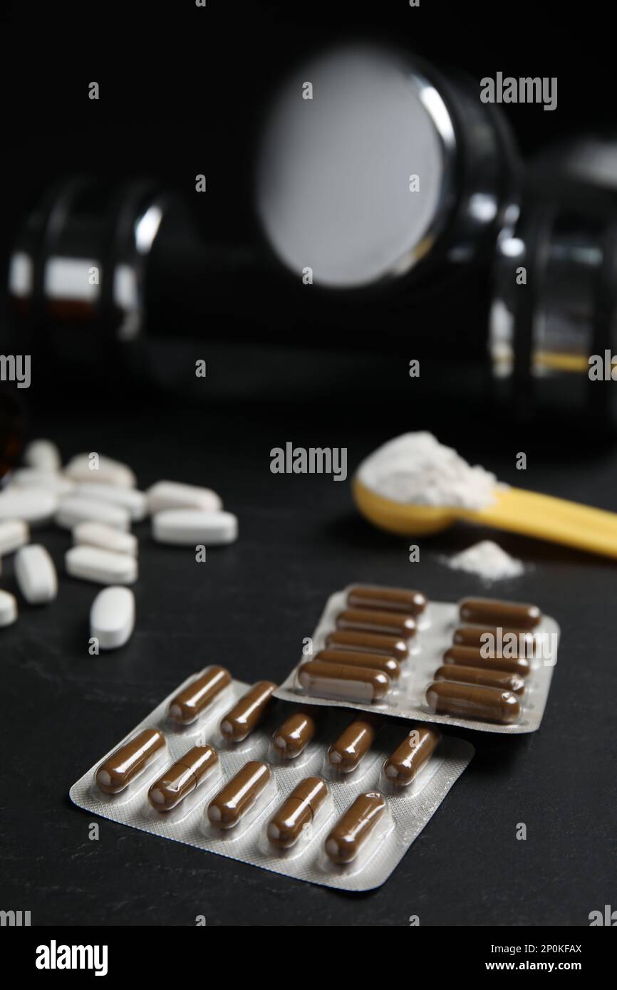 Confezioni blister con pillole di aminoacidi su tavolo nero Foto Stock