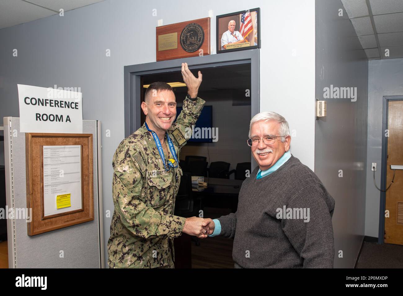 Frank Gasperetti, responsabile delle risorse di produzione, si è congratulato con Rick Nelson, proprietario del progetto Veterans Employee Readiness Group (VET-ERG), per essere stato uno dei primi riconosciuti nell'iniziativa di denominazione mensile delle sale conferenze del Codice 900. Foto Stock