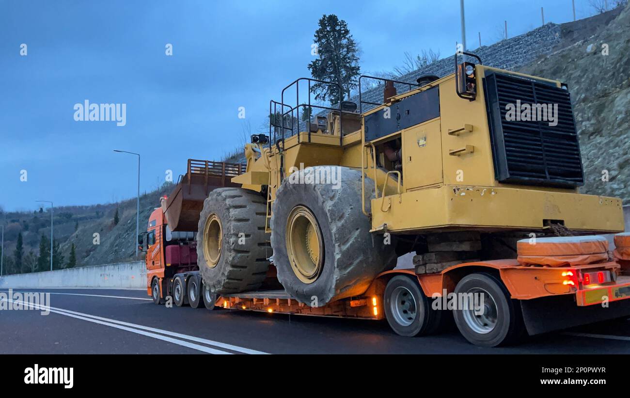 Trasporto della pala gommata di grandi dimensioni al prossimo cantiere minerario, trasporto pesante Foto Stock