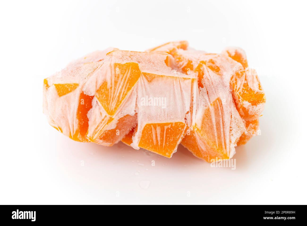 Zucca d'arancia tagliata a cubetti, e congelata per la conservazione, primo piano isolato su sfondo bianco Foto Stock