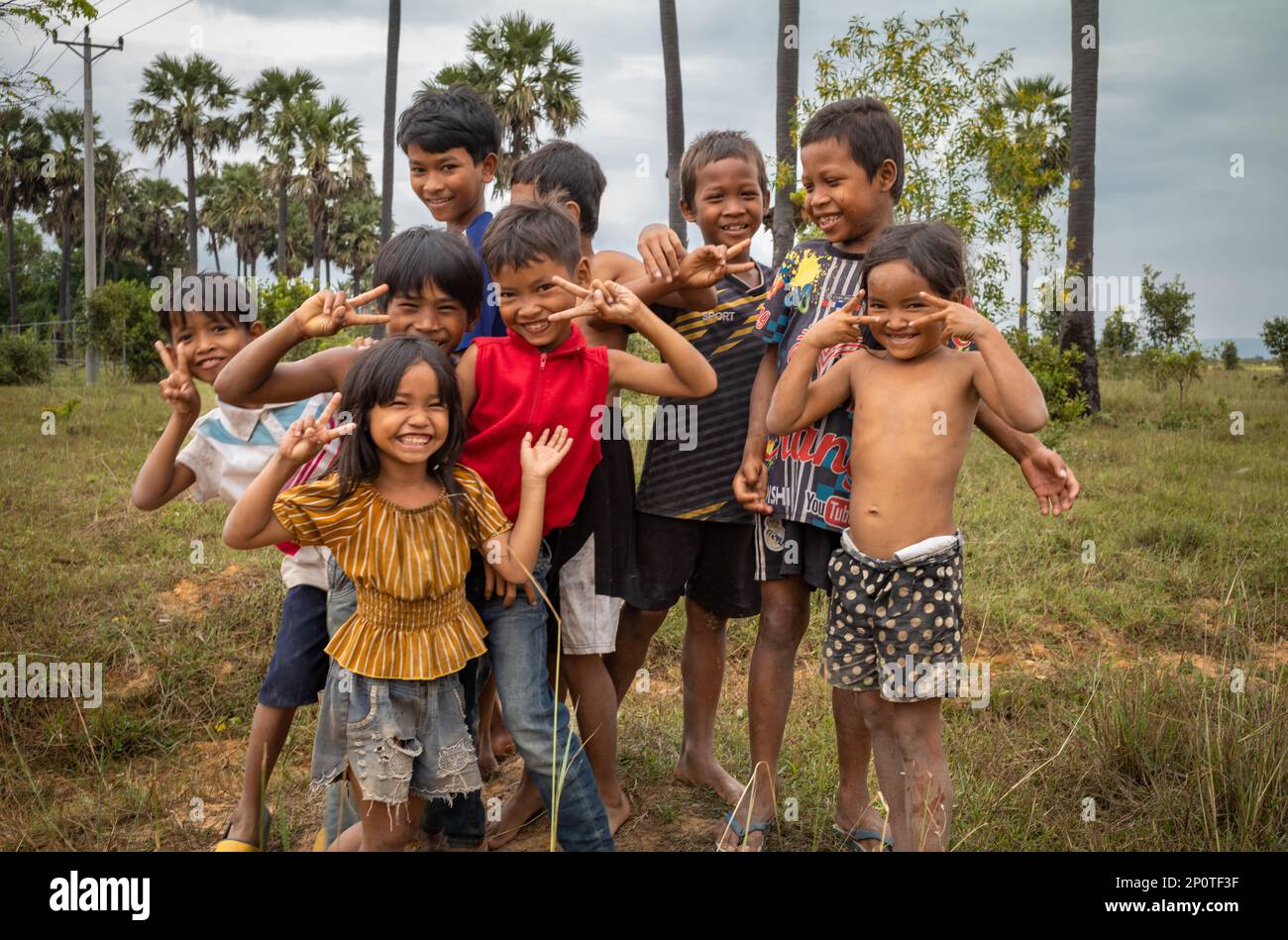 Un gruppo di bambini si posa mentre giocano in una terra desolata a Phumi Khna, nella provincia di Siem Reap, Cambogia. Foto Stock