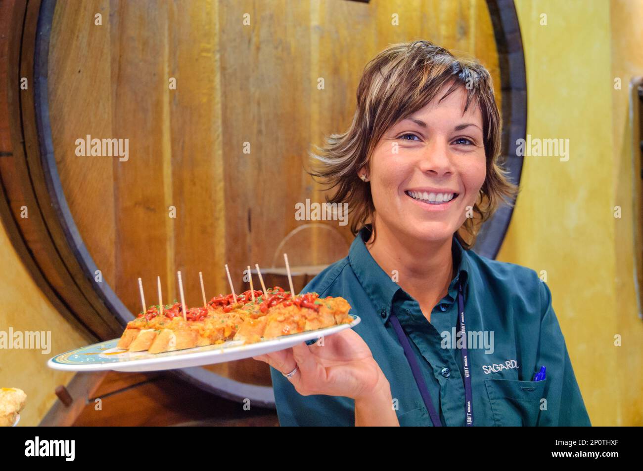 Cameriera che tiene un piatto di pinchos in un bar basco a Barcellona, Spagna Foto Stock