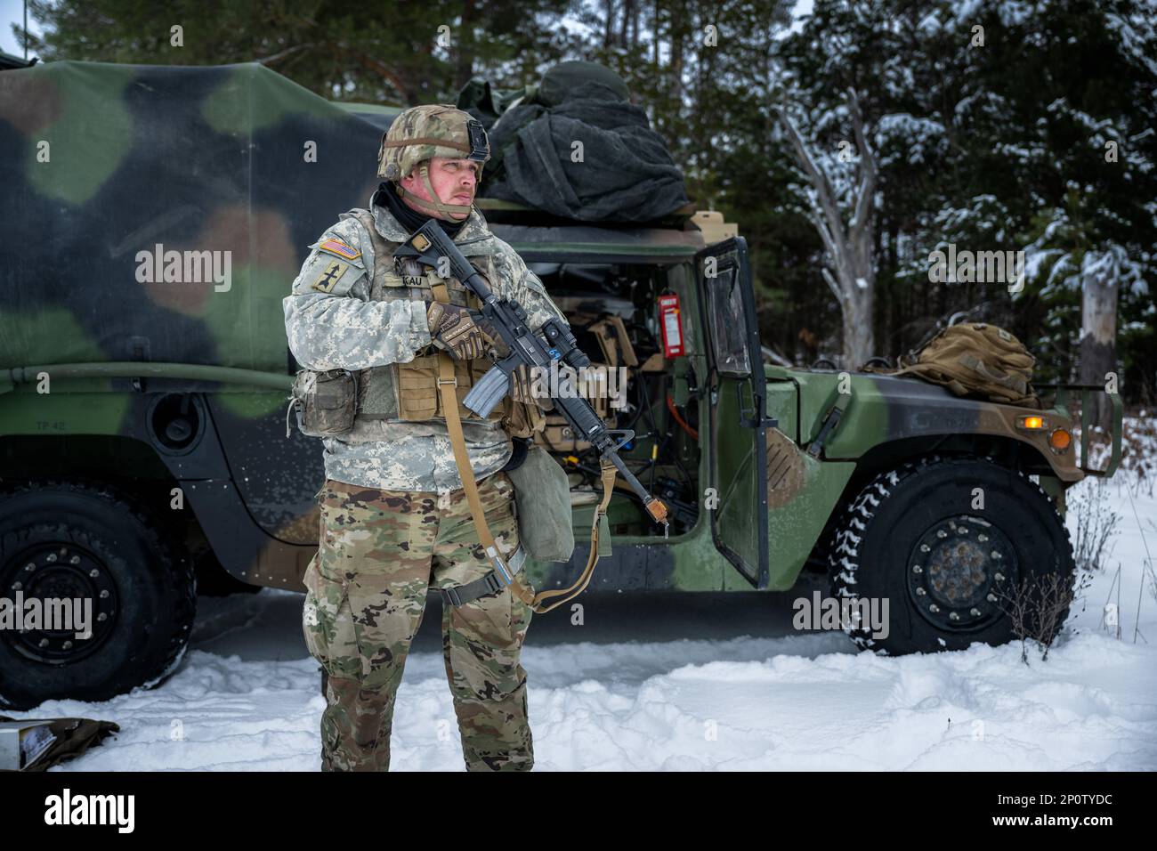 Christopher Kau, 1-120th Field Artillery Regiment, fornisce sicurezza mentre la squadra di armi crea un howitzer M119 durante Northern Strike 23-1, 25 gennaio 2023, a Camp Grayling, Michigan. Le unità che partecipano all’iterazione invernale di Northern Strike costruiscono la propria preparazione conducendo una formazione congiunta per le basse temperature, progettata per raggiungere gli obiettivi della strategia artica del Dipartimento della Difesa. Foto Stock