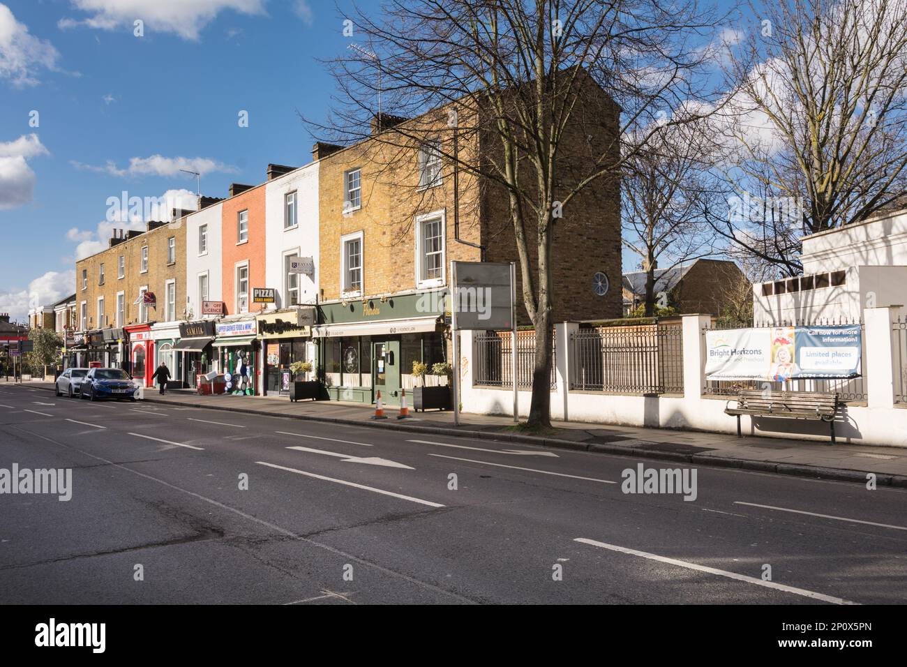 Una sfilata di negozi su Castelnau Shopping Parade, Barnes, Londra, SW13, Inghilterra, REGNO UNITO Foto Stock