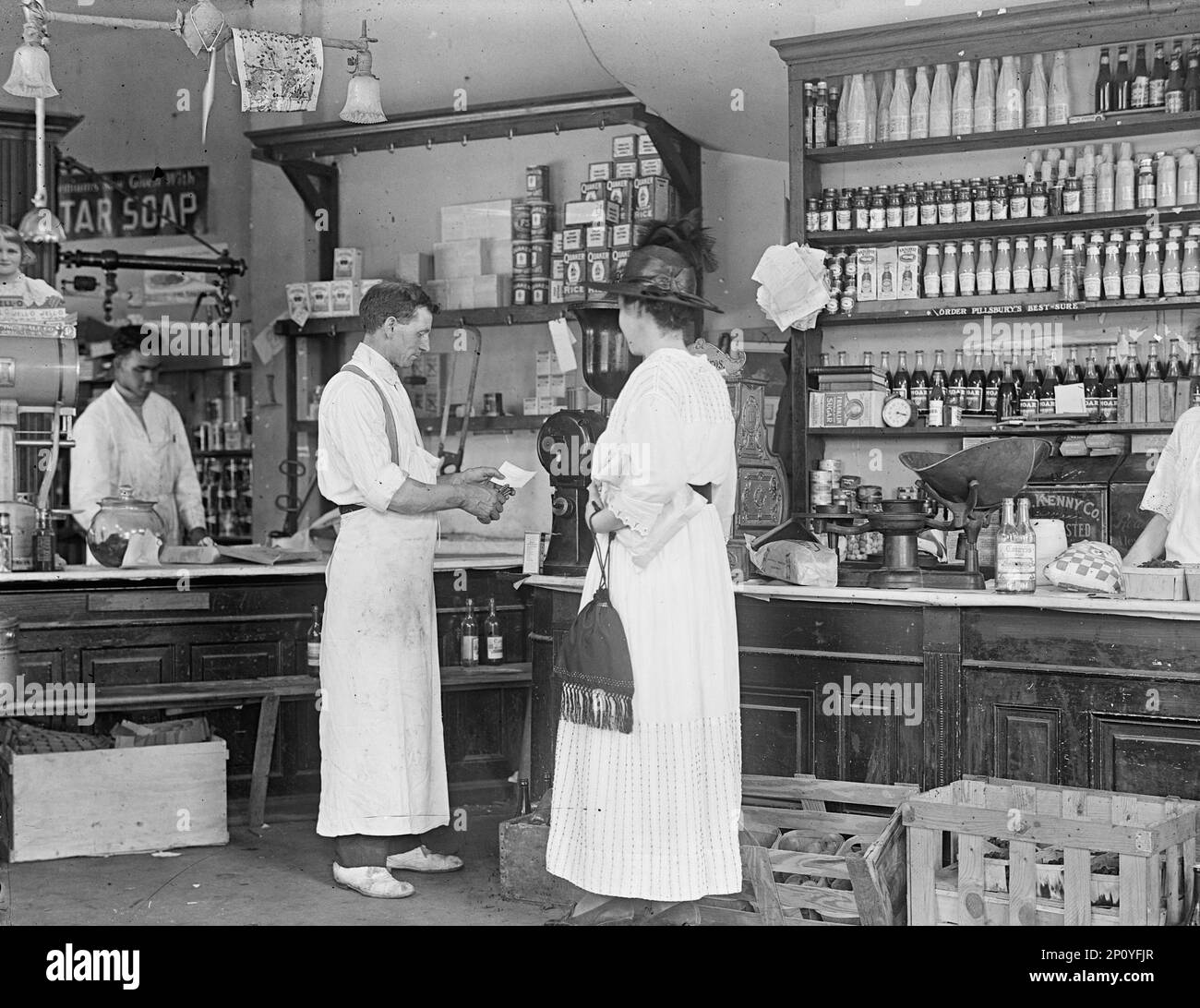 Store interno, 1917 o 1918. Prima guerra mondiale - assistente del negozio e cliente. Foto Stock