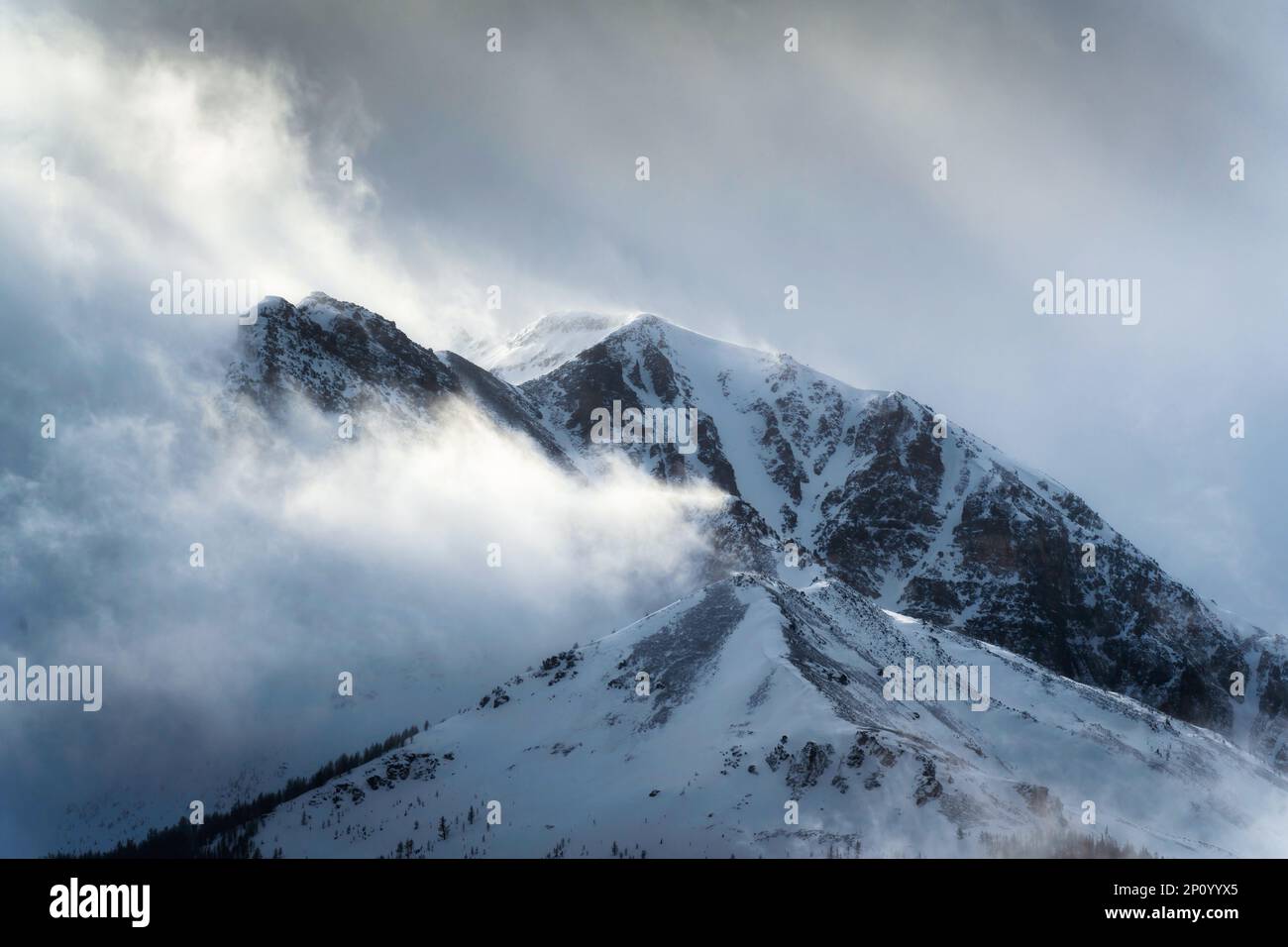 Maestose montagne rocciose innevate con la luce del sole che splende nella natura selvaggia del parco nazionale Foto Stock