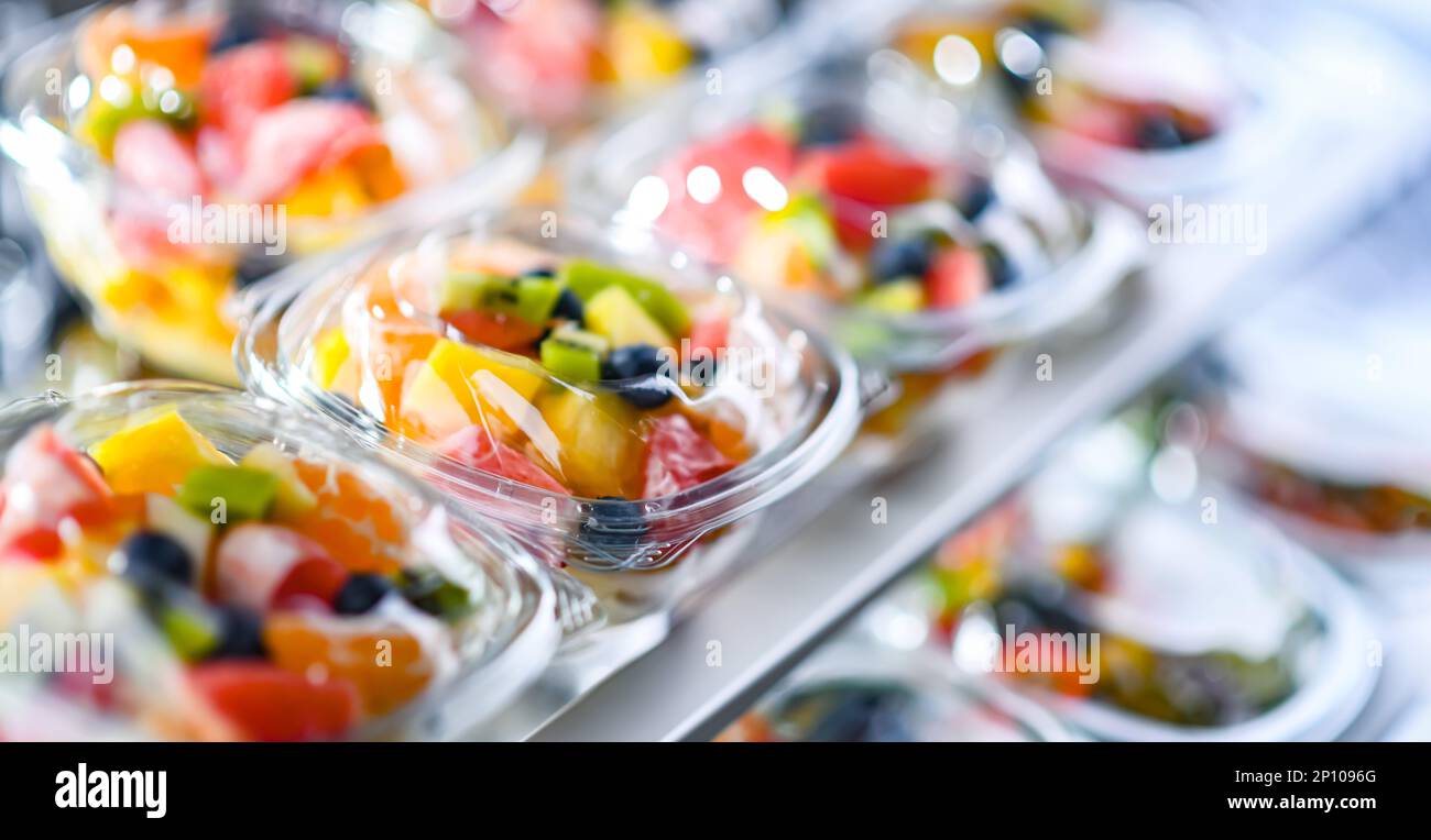 Scatole di plastica con macedonie di frutta preconfezionate, messe in vendita in un frigorifero commerciale Foto Stock