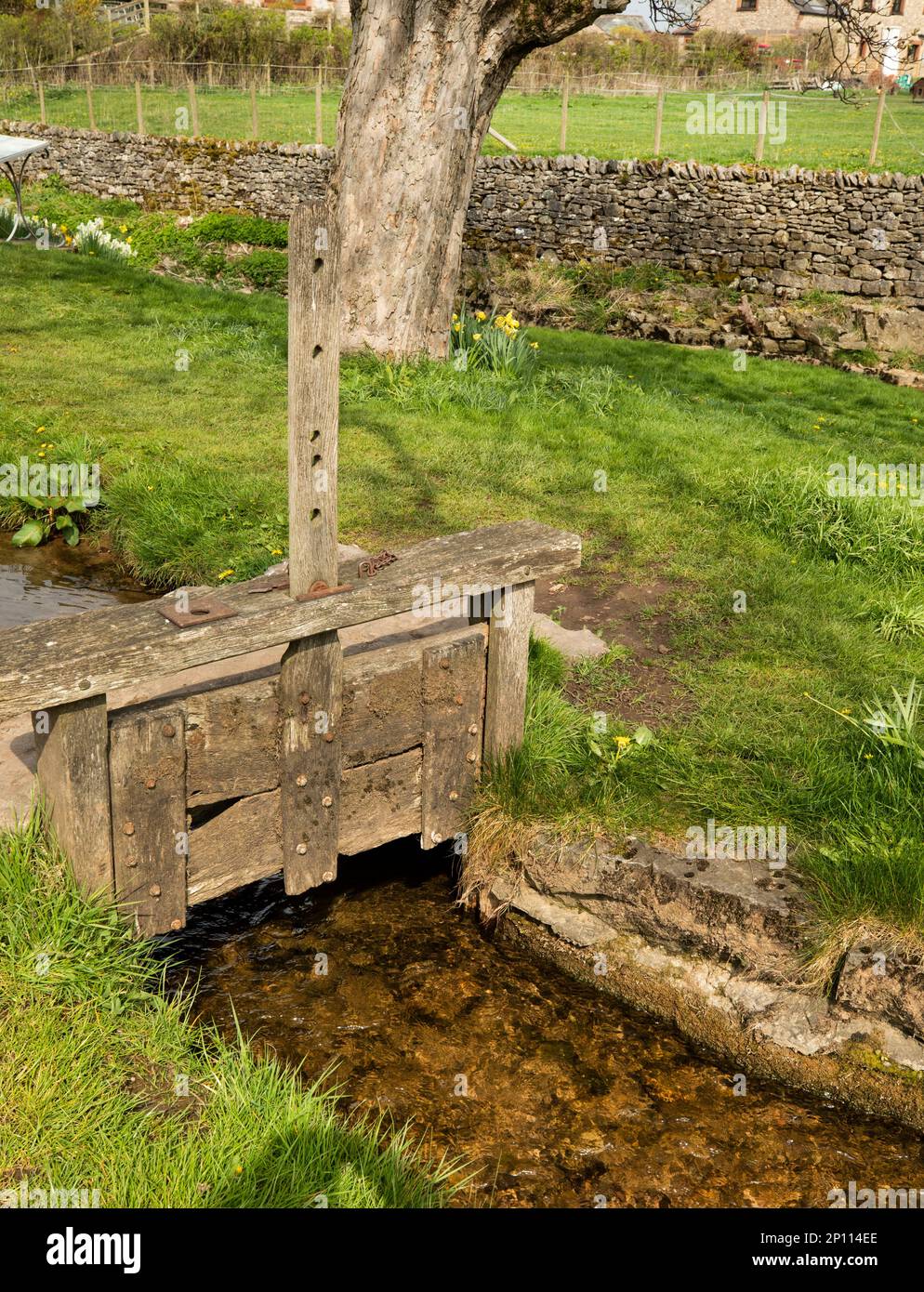 Vecchia porta medievale di legno per liberare l'acqua dal torrente, Morland Village, Eden Valley, North Pennines, Inghilterra Foto Stock