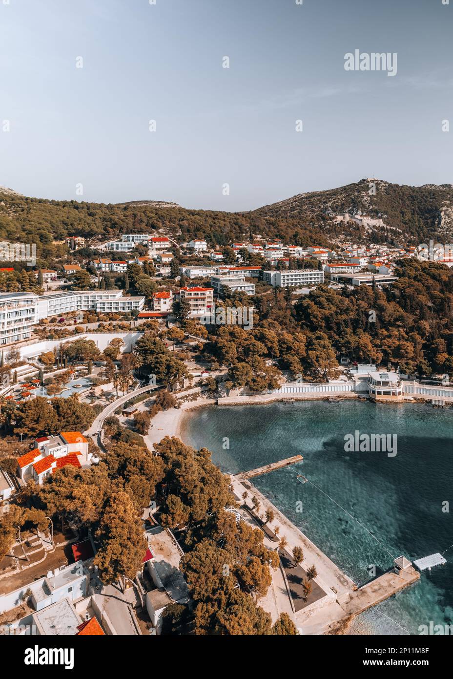 La ripresa aerea cattura la bellezza della costa di Hvar all'alba di una mattina d'estate. Le acque cristalline e le aspre scogliere sono illuminate dal Foto Stock