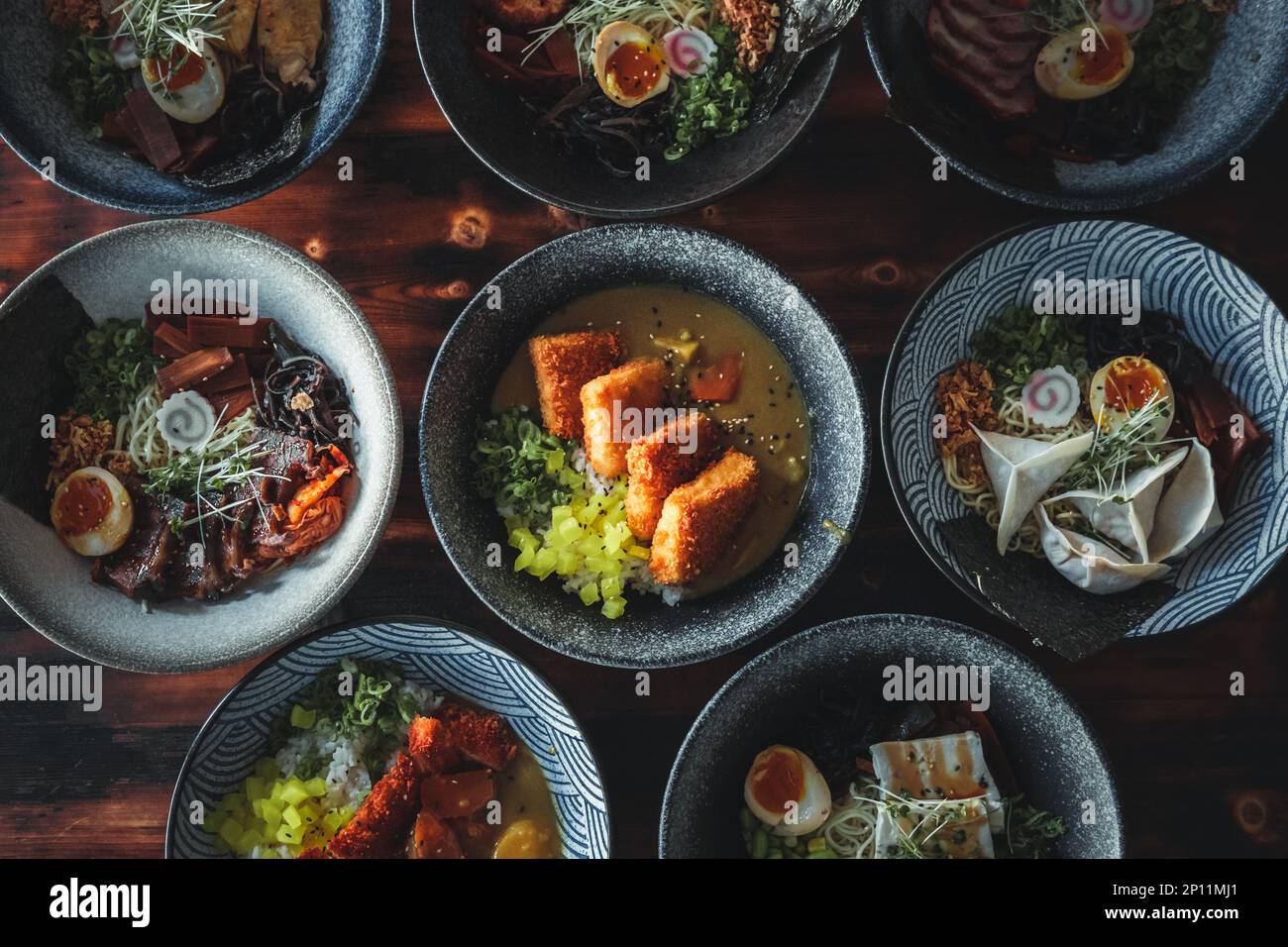 Una vista dall'alto verso il basso della cucina tailandese e asiatica, con una varietà di piatti con ingredienti colorati, decorazioni intricate e una presentazione mozzafiato. Foto Stock