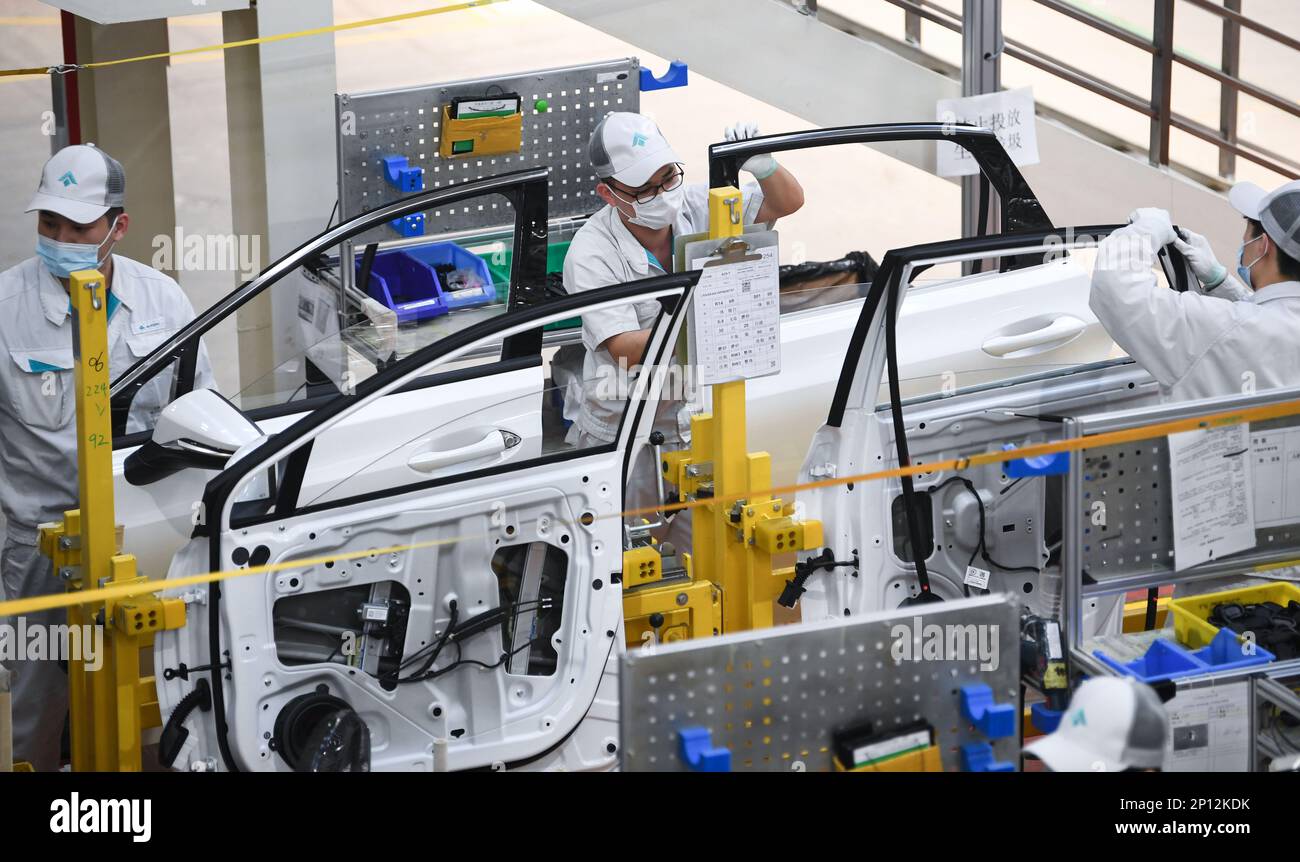 (230303) -- GUANGZHOU, 3 marzo 2023 (Xinhua) -- i membri del personale installano strisce di tenuta per porte nella linea di assemblaggio di GAC Aion, una filiale NEV di Guangzhou Automobile Group Co., Ltd. (Gruppo GAC), a Guangzhou, provincia del Guangdong, 24 febbraio 2023. Guangzhou, una delle principali basi di produzione automobilistica della Cina, ha cercato di attrarre investimenti nell'industria NEV negli ultimi anni. (Xinhua/Deng Hua) Foto Stock