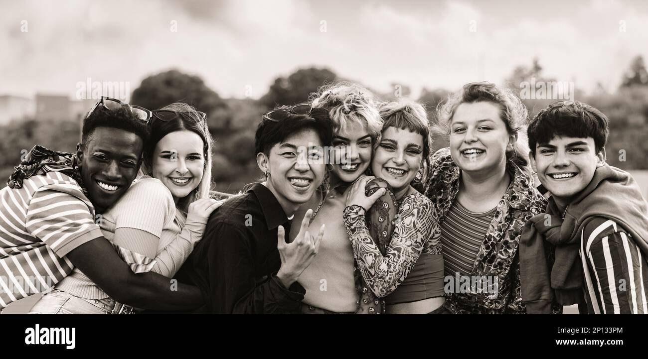 Giovani amici multietnici che si divertono insieme in città - concetto di amicizia e diversità - montaggio in bianco e nero Foto Stock