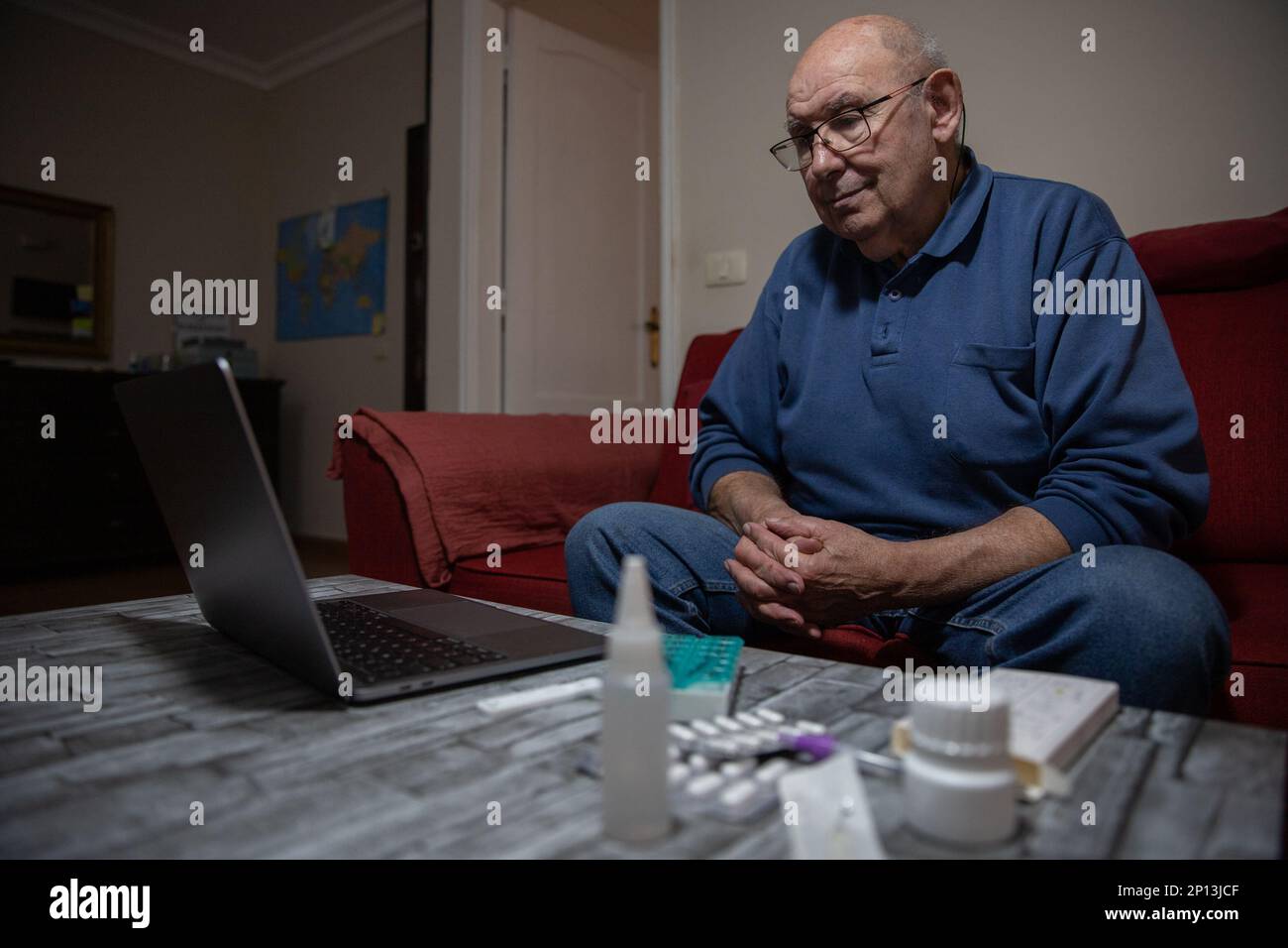 Un uomo anziano effettua una videochiamata con il suo medico generico, il concetto di telesorveglianza Foto Stock