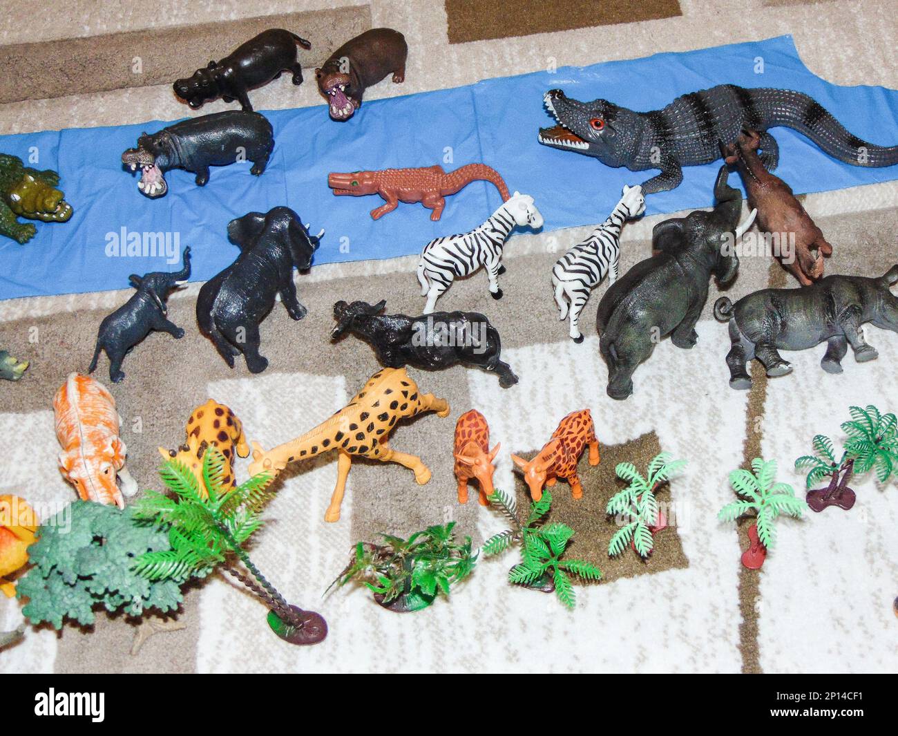 Animali giocattolo africani posti su tappeto da un bambino Foto Stock