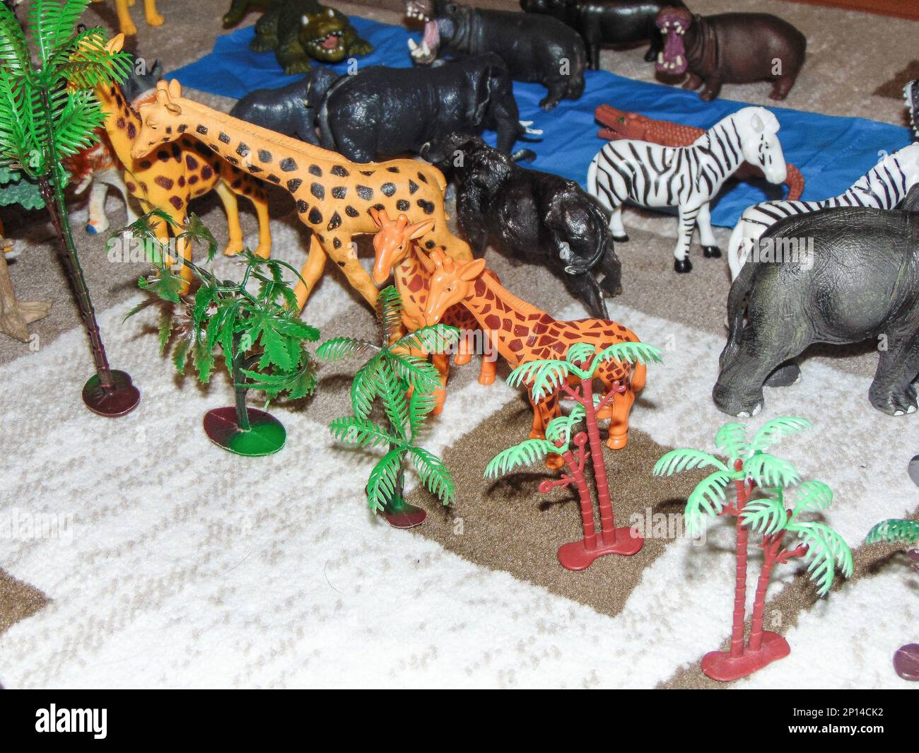Animali giocattolo africani posti su tappeto da un bambino Foto Stock