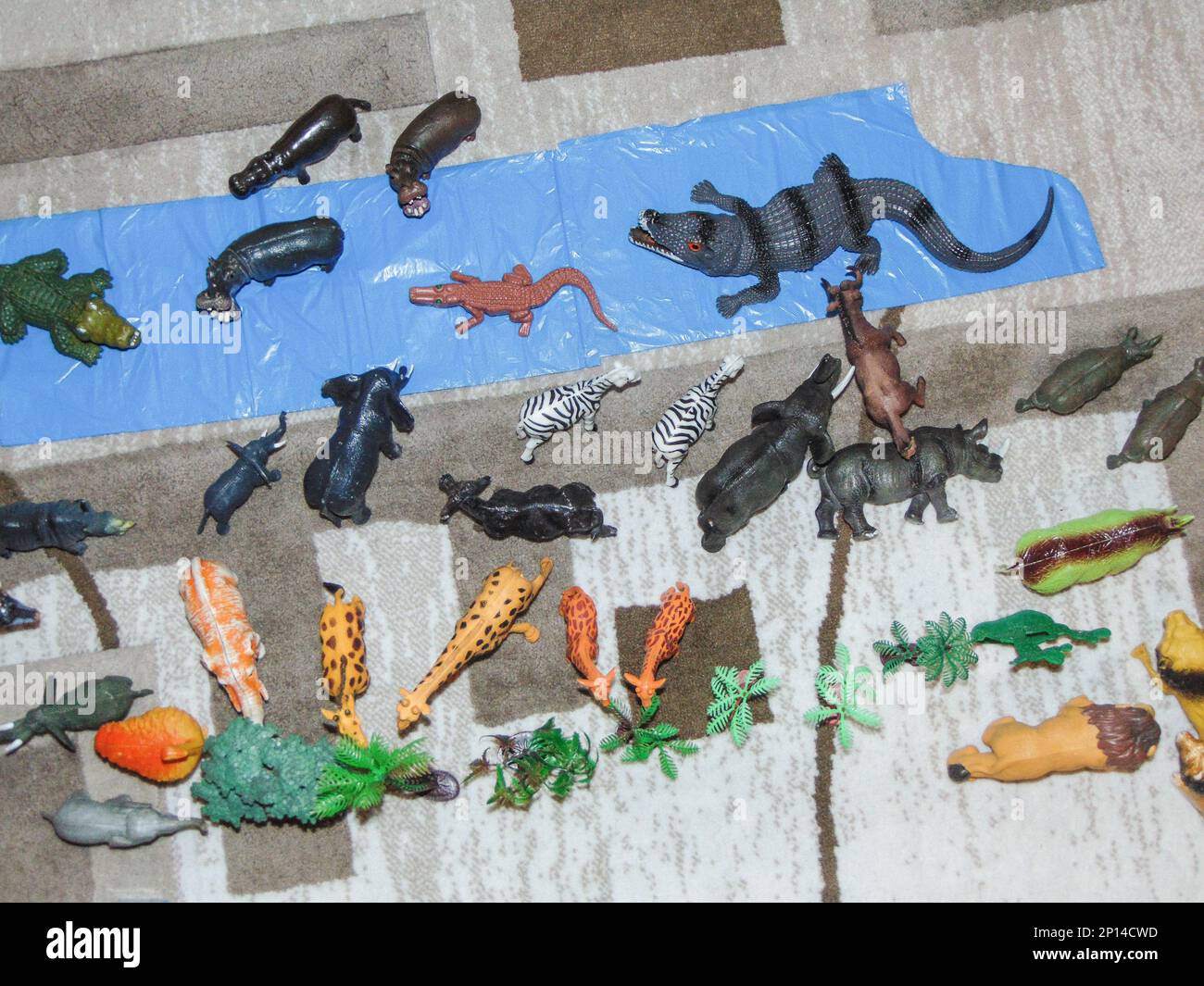 Animali giocattolo africani posti su tappeto da un bambino Foto Stock