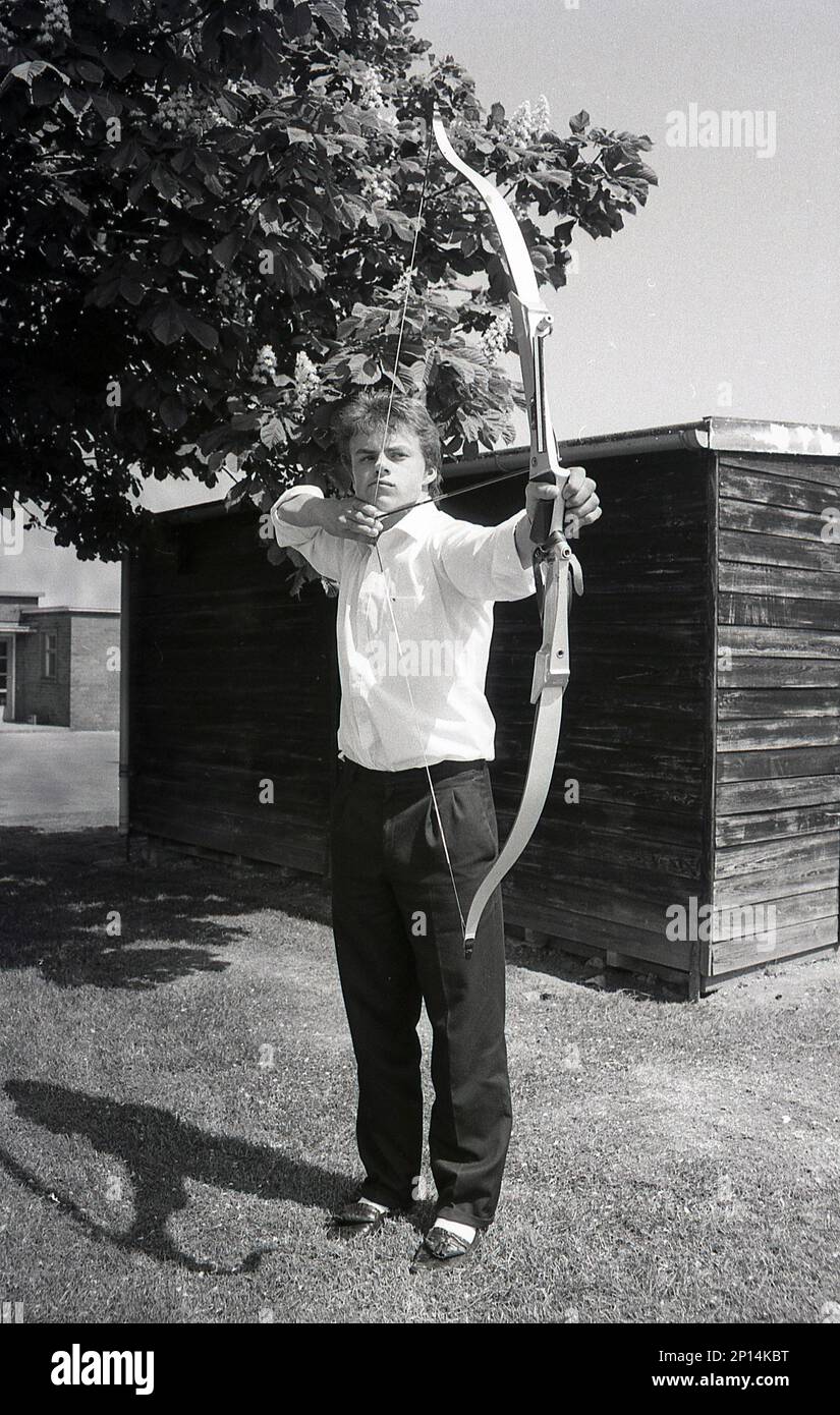 1989, ragazzo adolescente con arco freccia abd prendere la mira, tiro con l'arco, Inghilterra, Regno Unito. Foto Stock
