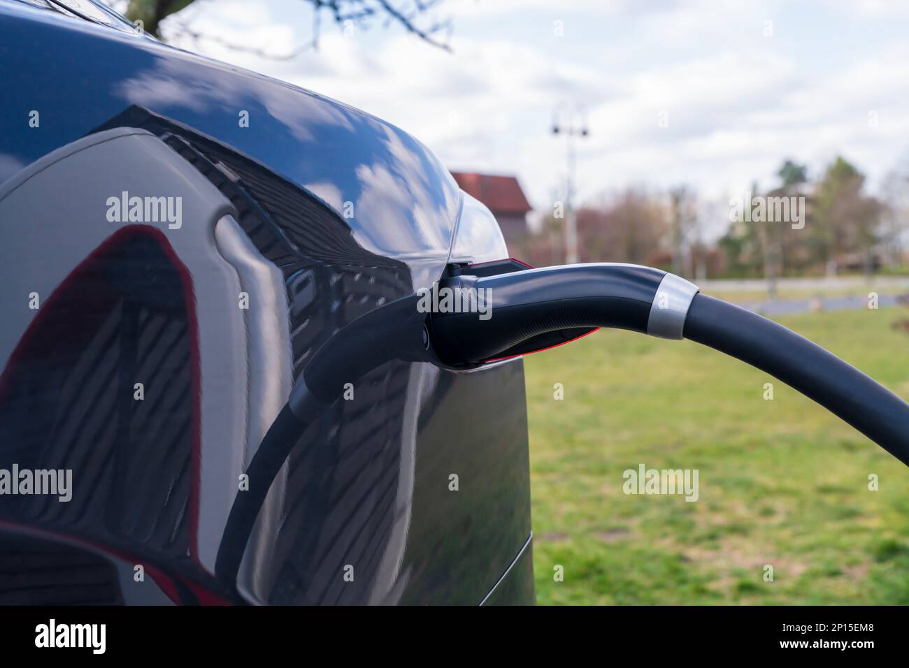 Collegare il cavo di ricarica a un'auto elettrica Foto Stock