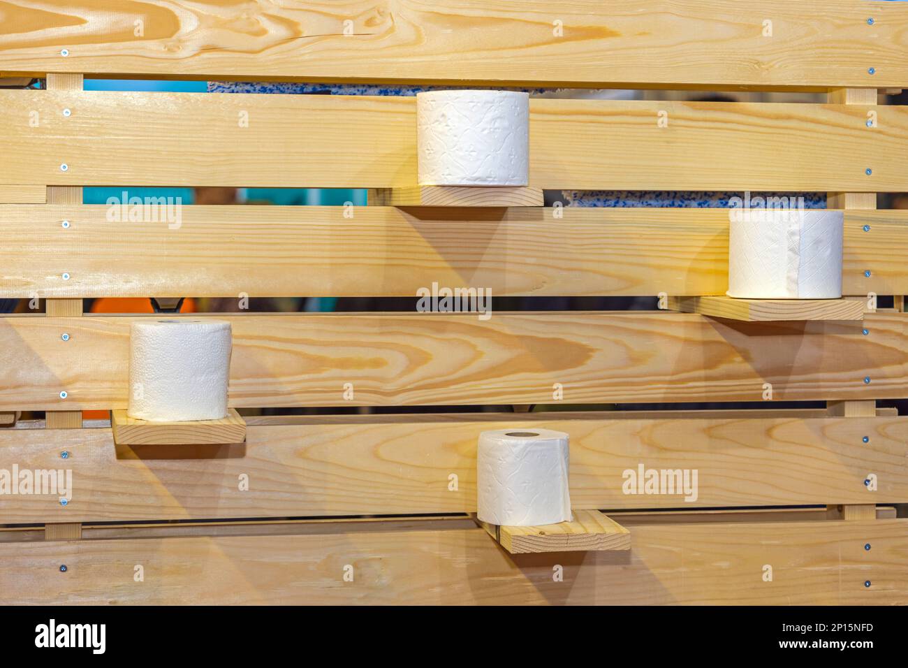Rotoli di carta igienica presso un ripiano in legno nella cabina bagno Foto Stock