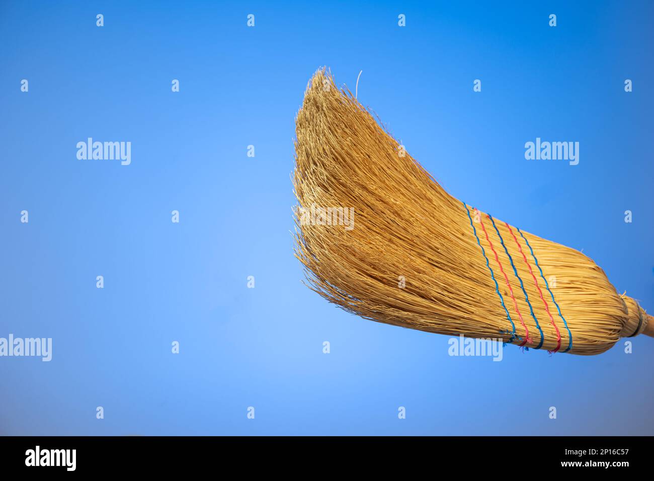 Dettaglio primo piano della scopa intrecciata isolato su sfondo blu. Foto Stock