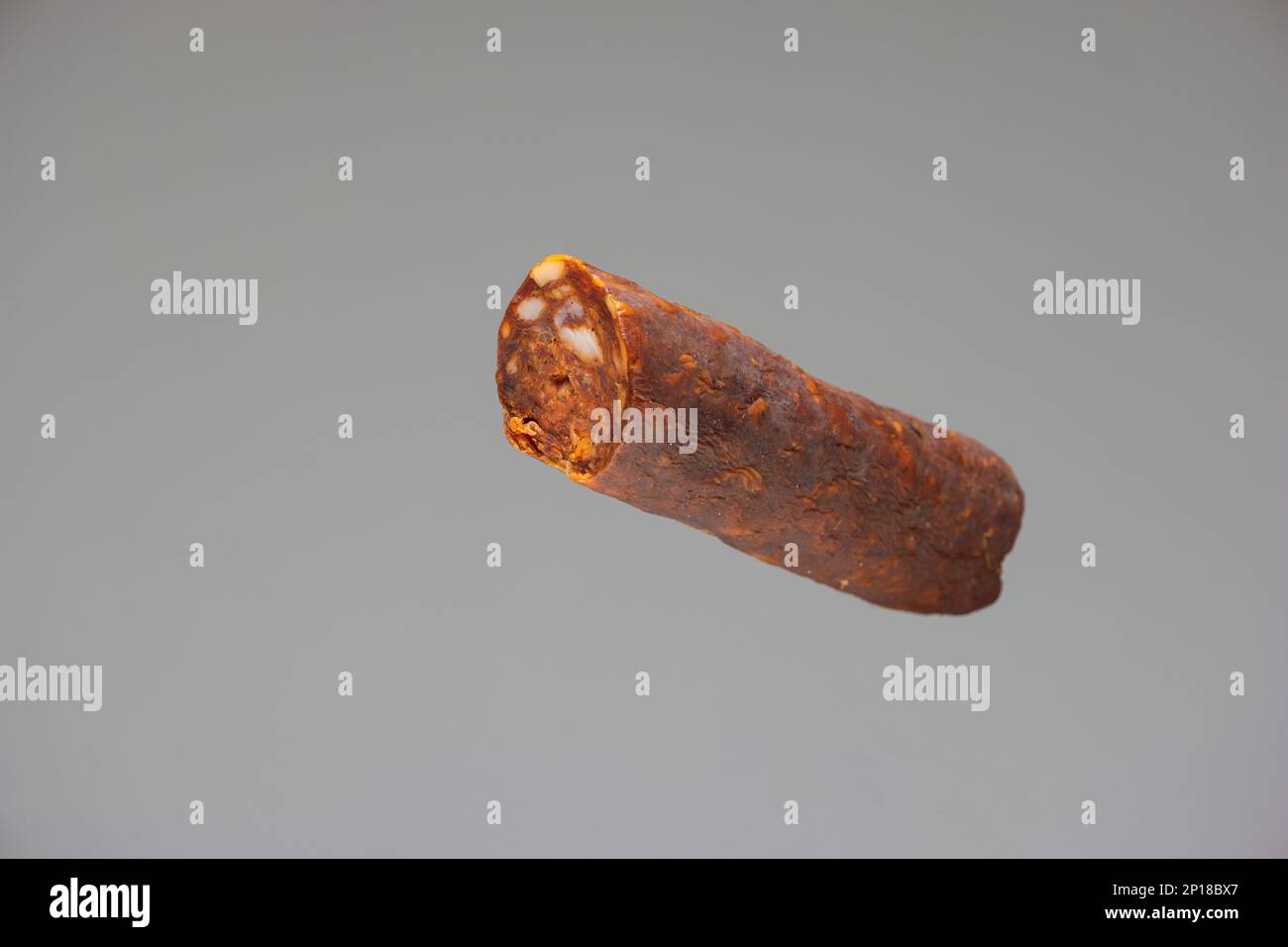 Salame piccante affumicato in stile ungherese primo piano girato studio isolato su sfondo grigio. Foto Stock