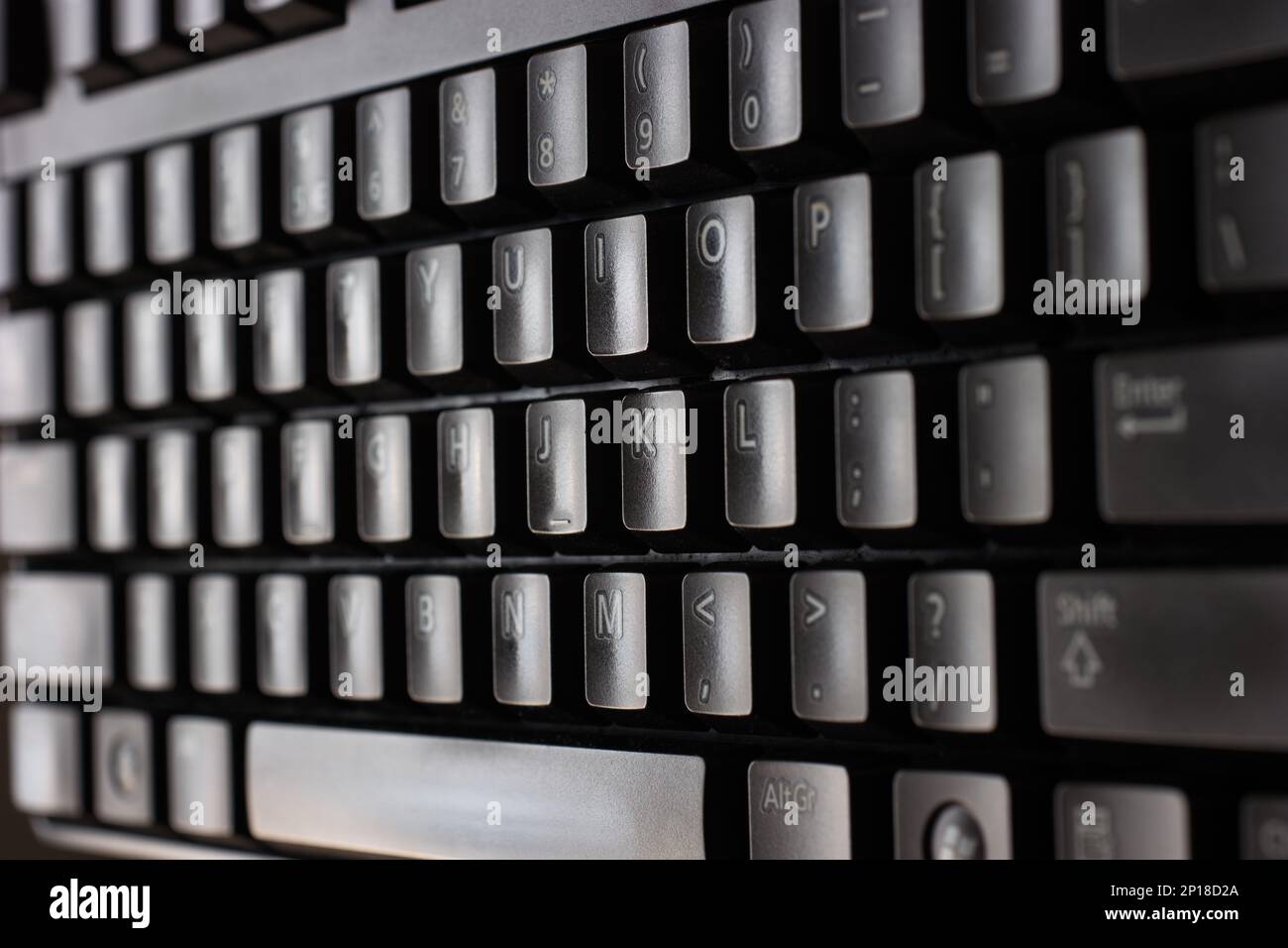 Nero plastica standard inglese tastiera computer primo piano macro shot vista laterale superiore. Foto Stock