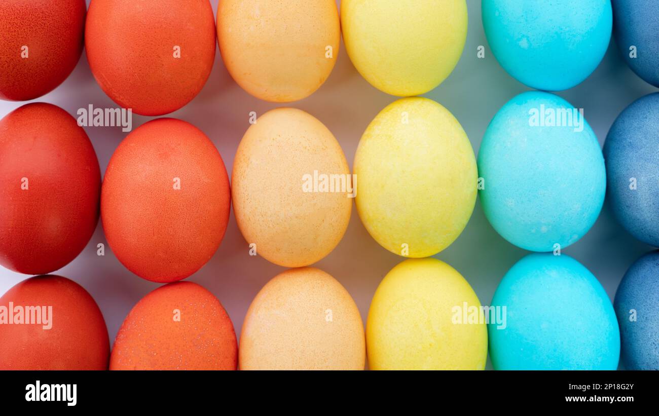 Sfondo con uova di pasqua color arcobaleno. Le uova sono dipinte nei colori dell'arcobaleno e disposte a gradiente. Modello di uova di Pasqua per sfondi. EA Foto Stock