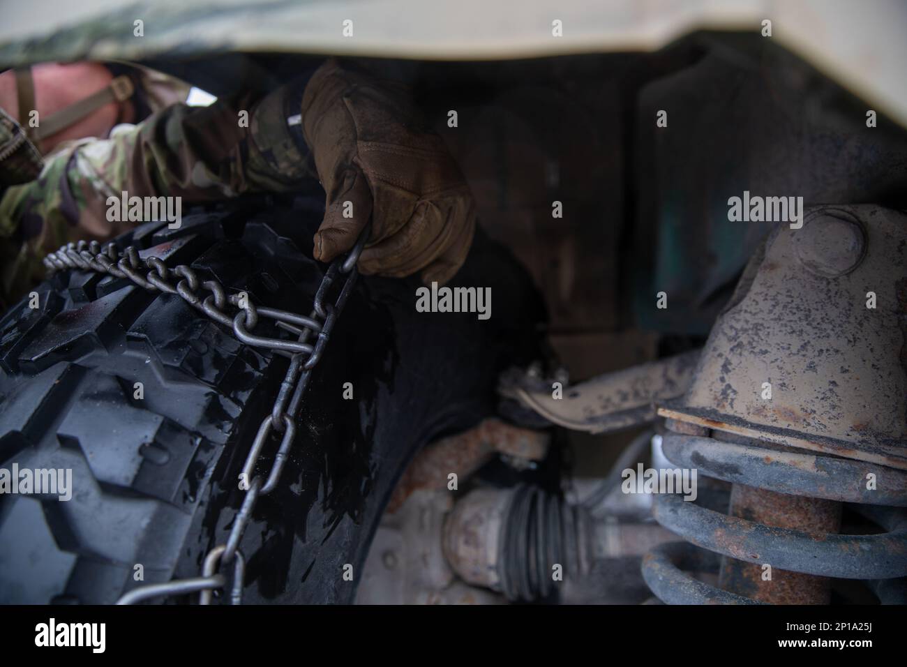 10th soldati di montagna lavorano insieme per mettere catene da neve su un HMMV in meno di 10 minuti. Le squadre gareggiano per il tempo più veloce prima di passare all'esercizio successivo. Foto Stock