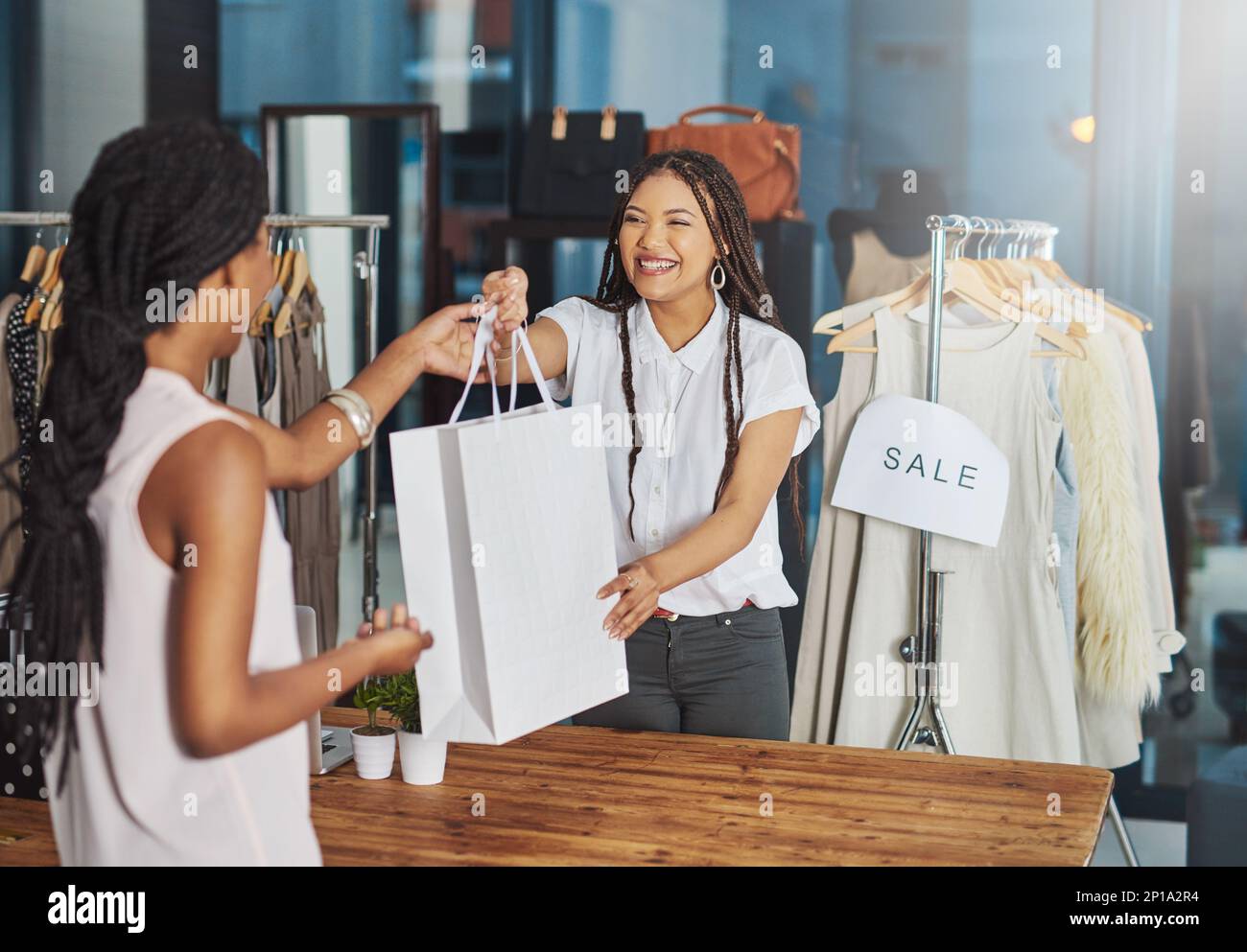 Crede nel sostegno dell'azienda locale. Scatto ritagliato di un giovane proprietario del negozio che consegna un pacco a un cliente al banco. Foto Stock