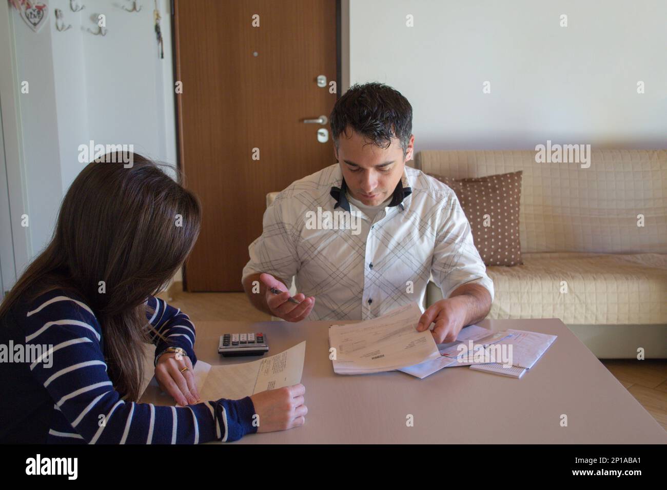 Immagine di una coppia che effettua calcoli e controlla fatture e note spese. Problema di crisi finanziaria. Foto Stock