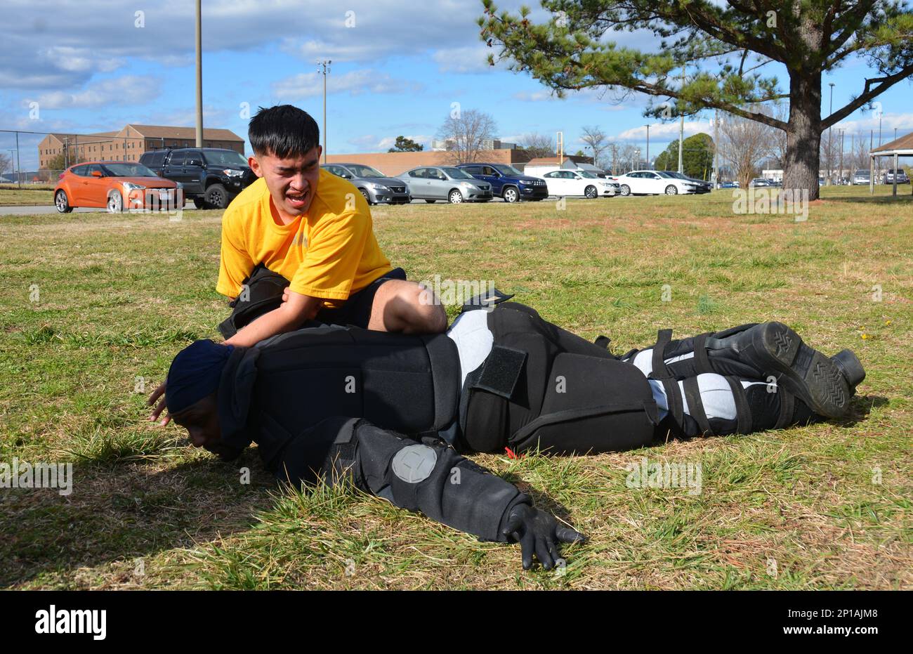 PORTSMOUTH, Virginia (20 gennaio 2023) il compagno di Boatswain Seaman Kevin Calderon utilizza un controllo di avanzamento meccanico (MAC) per spostarsi sull'assailant "uomo rosso" dopo essere stato spruzzato con lo spray Oleoresin capsicum (OC) durante l'addestramento di base della forza di reazione di sicurezza (SRF-B) presso il cantiere navale di Portsmouth. SRF-B è un corso completo di due settimane che fornisce conoscenze di base per i marinai per svolgere il ruolo di sentry. Foto Stock