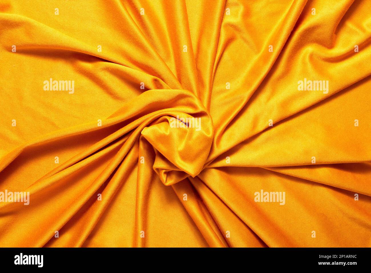 Un primo piano di un tessuto giallo seta vorticoso in una vasca idromassaggio Foto Stock