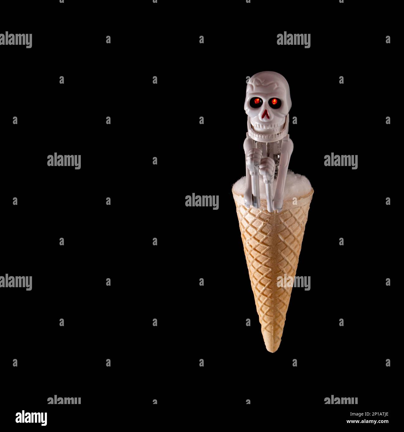 Immagine di un cono gelato sormontato da una figura scheletrica su sfondo nero Foto Stock