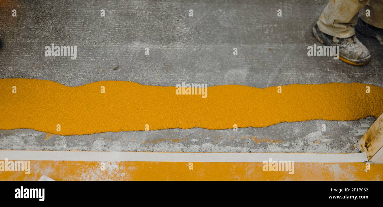 Nuovo pavimento in cemento lucidato ricoperto da uno strato di resina epossidica gialla Foto Stock