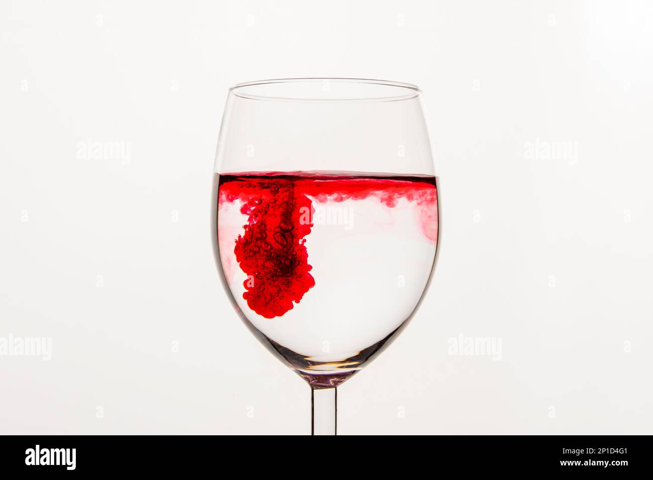 Liquido vorticoso rosso in una tazza di vetro trasparente Foto Stock