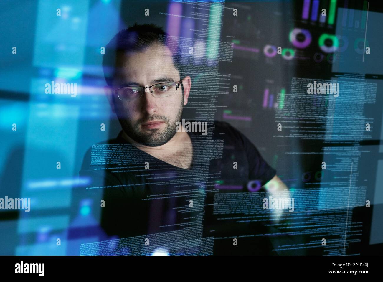Attenzione a non perdersi nel codice. Scatto ritagliato di un giovane programmatore di computer che guarda attraverso i dati. Foto Stock