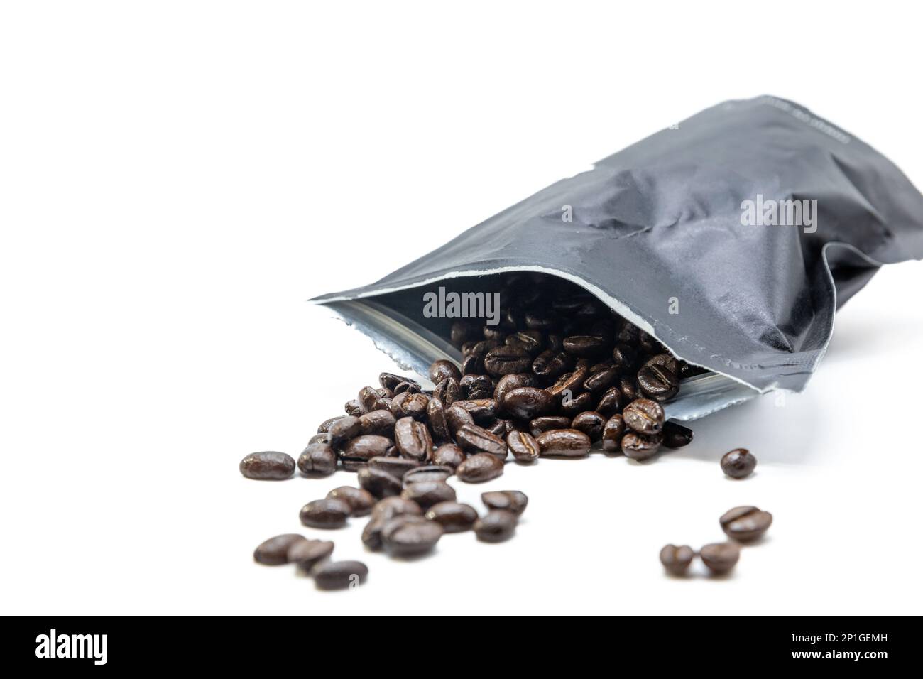 Sacchetto per aspirapolvere nero per il caffè da cui fuoriescono i chicchi di caffè. Isolato su bianco. Foto Stock