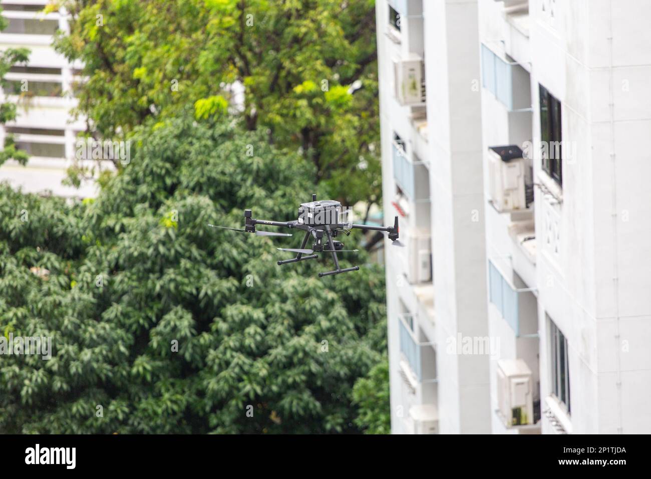 Un drone in volo a metà volo sta effettuando un'ispezione dell'edificio per identificare eventuali difetti critici di una condizione dell'edificio. Singapore. Foto Stock
